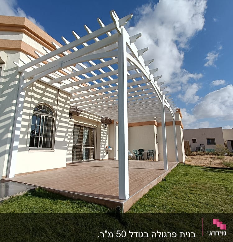 פרגולה לבנה מעץ על דק עץ בגינה